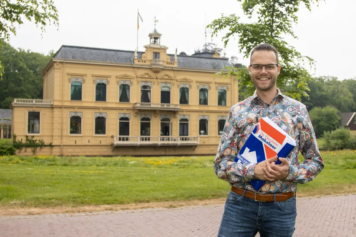 NVM-makelaar Wieger van der Velde met een brochure van De Flexibele Makelaar bij de Borg Nienoord in Leek